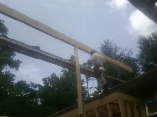 Carpenter setting a ridge beam over a new addition frame — Ice Dam Removal by Roofing Brothers in Entiat