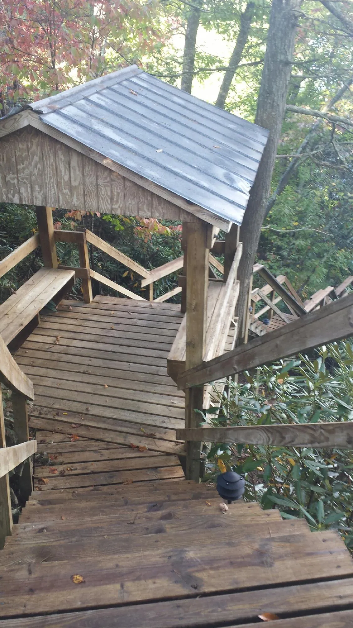 Metal roofed shelter over wooden steps on a wooded walkway — Skylight Repair & Installation work by our crew in Entiat